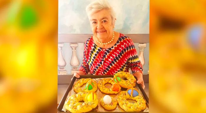 Nonna Romana holds a scarcella, a traditional braided Easter bread adorned with colorful hard-boiled eggs. Her granddaughter, Rossella Rago, recalls that Nonna made these for all the kids every Easter.