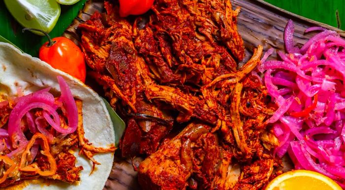 Cochinita pibil is a traditional pork dish from the Yucatán Peninsula, slow-cooked for many hours to develop its rich, flavorful taste.