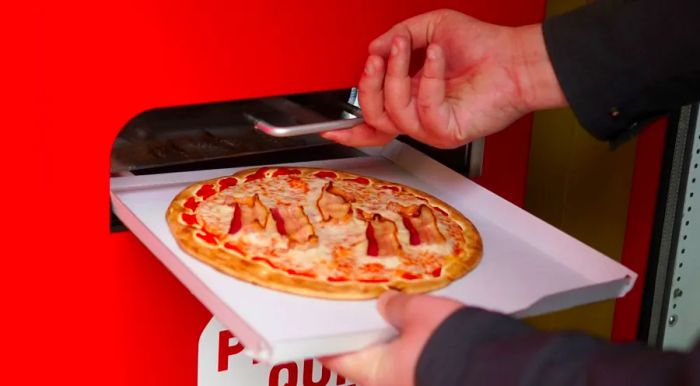 The pizza emerges on its preheated tray.