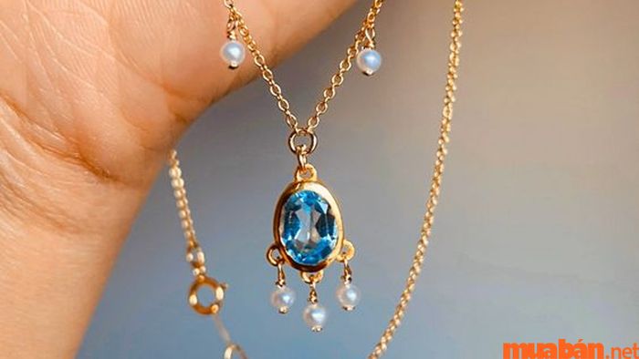 Vòng cổ vàng kết hợp với Topaz xanh dương đậm tạo nên một vẻ ngoài quý phái, mang lại nét sang trọng và đầy cuốn hút.