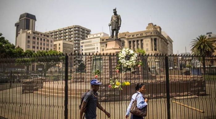 A statue of Paul Kruger is positioned behind barbed wire in Church Square.