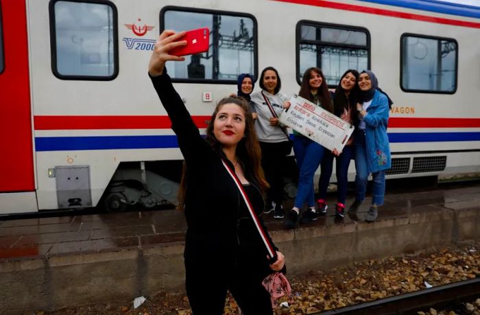 Before the Eastern Express pulls out of Ankara, a traveler takes a selfie with friends, capturing the moment of departure.