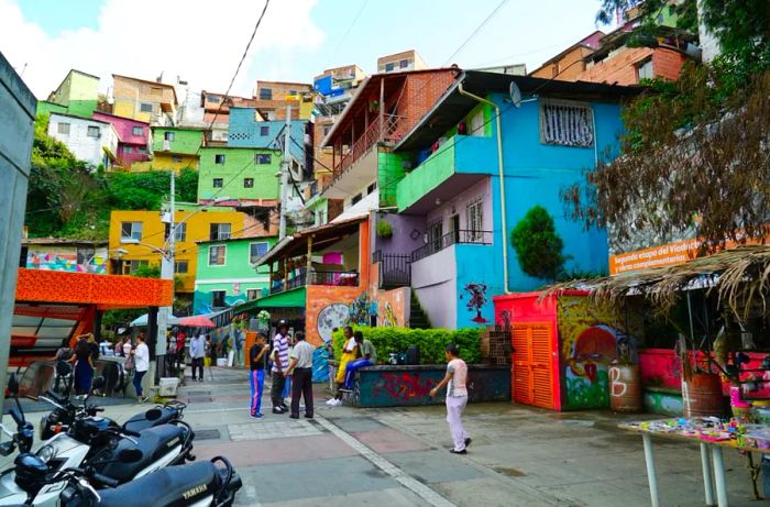 The streets of Medellín are lined with vibrant, colorful houses and bustling food stalls.