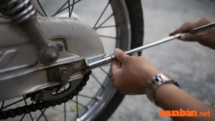 Kiểm tra và điều chỉnh độ căng dây sên ở cả hai bên trục xe máy để đảm bảo sự đồng đều.