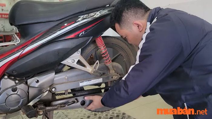 Tháo nắp hộp sên để chuẩn bị cho việc điều chỉnh sên xe máy.