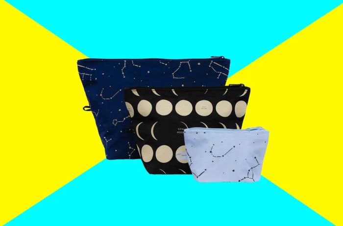 Three Baggu pouches in black, tan, and white, each with unique patterns of constellations and moon phases