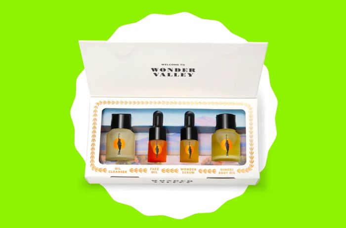 A set of four travel-size skincare bottles neatly arranged in a white rectangular box.