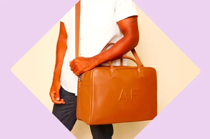 Man holding brown leather weekend bag