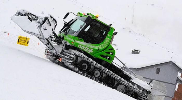 A hybrid green snow groomer operates in Val Thorens, located in the French Alps.