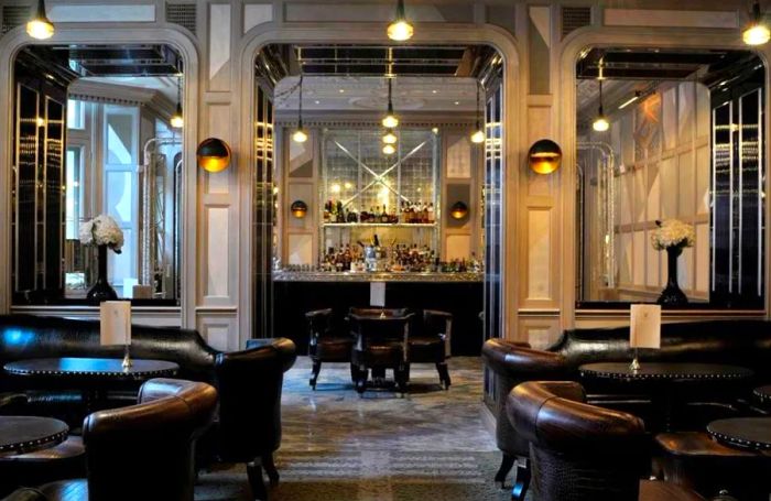 London's Connaught Bar exudes elegance with its towering mirrored ceilings, platinum silver walls, and sleek white marble floors, offering an upscale ambiance without the pretension.