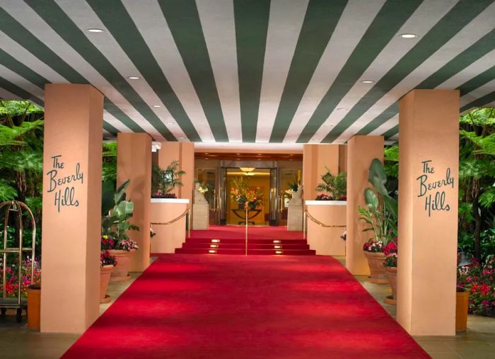 The iconic green stripes and rich red carpet guide guests through the grand entrance of the Beverly Hills Hotel.