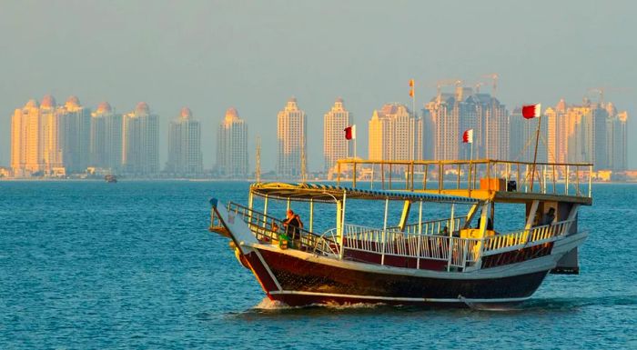 A traditional dhow glides gracefully across the waters of Doha Bay.