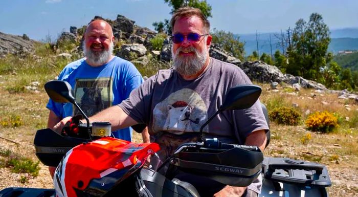 Bill Mauro (right) and Marcus Laurence ride ATVs near their home in the mountains outside Coimbra.