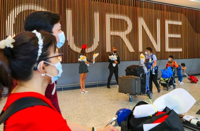 International travelers who recently arrived at Melbourne Airport walk through the international arrivals hall on November 1, 2021.