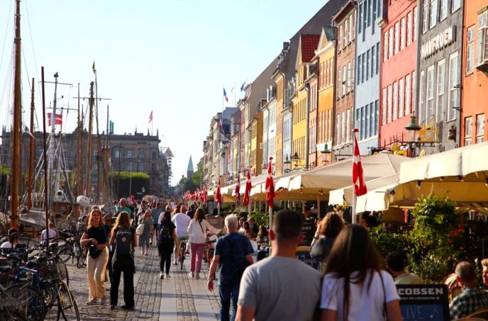 On September 3, people stroll through Nyhavn, the vibrant harbor in Copenhagen, Denmark’s capital, known for its colorful buildings and popularity with tourists.