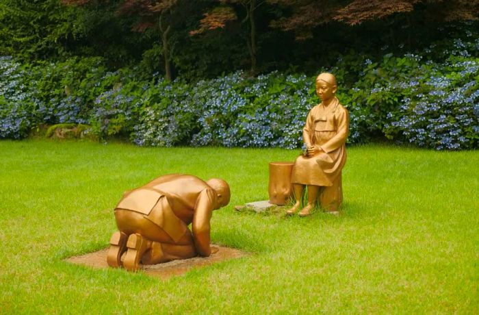 A statue representing Japanese Prime Minister Shinzo Abe bowing deeply in apology to 'comfort women' stands at the Korea Botanic Garden in Pyeongchang, South Korea, on July 28, 2020.