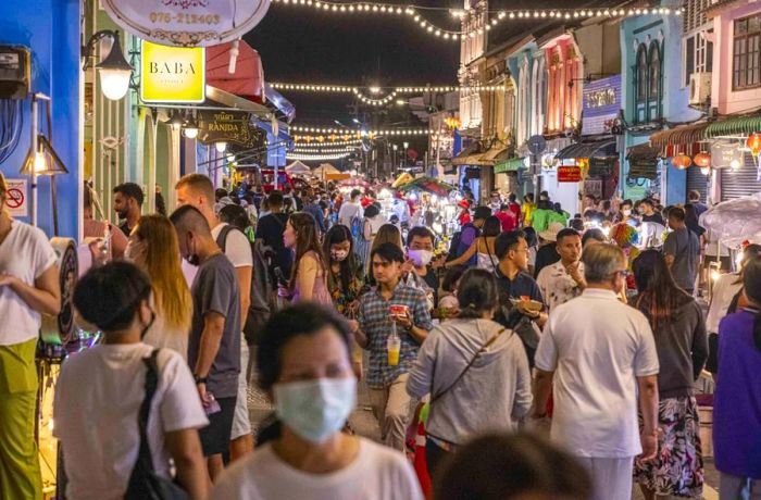 On October 2, tourists and locals are seen browsing a bustling street market in Phuket, Thailand.