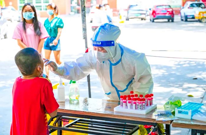 On August 7 in Sanya, a medical worker administers a Covid test to a child.