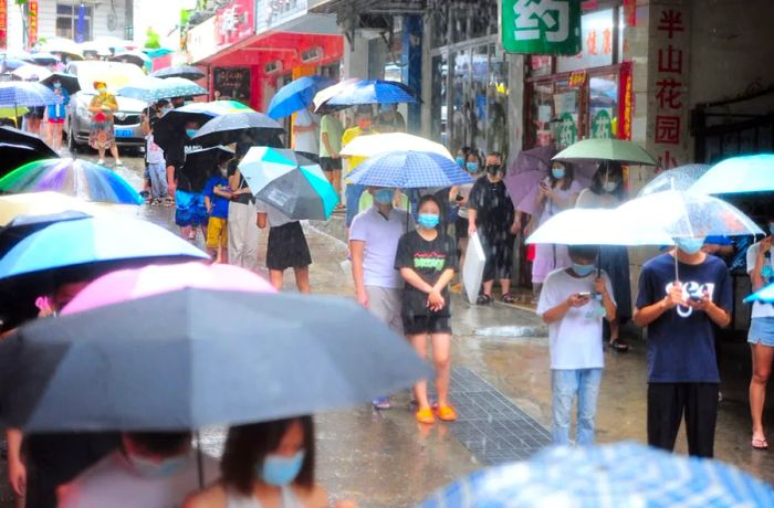 On August 8 in Sanya, known as 'China's Hawaii,' residents lined up in pouring rain to undergo Covid testing.