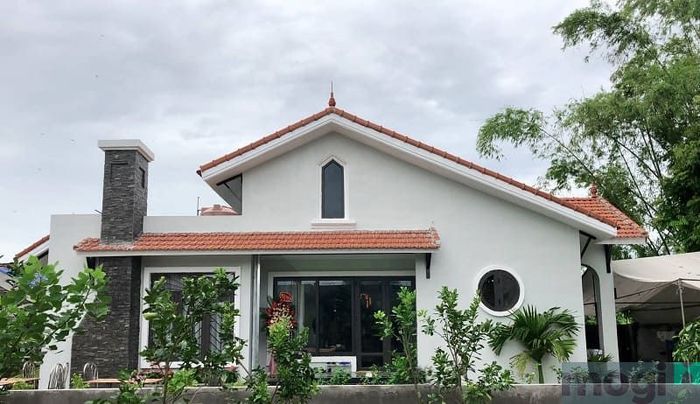 Căn nhà với mái Thái đơn giản và ống khói nổi bật, tạo điểm nhấn thú vị.