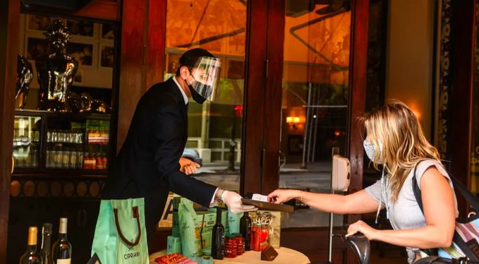 A customer pays for a to-go order at Cipriani restaurant on May 22, 2020, in New York’s Soho neighborhood.