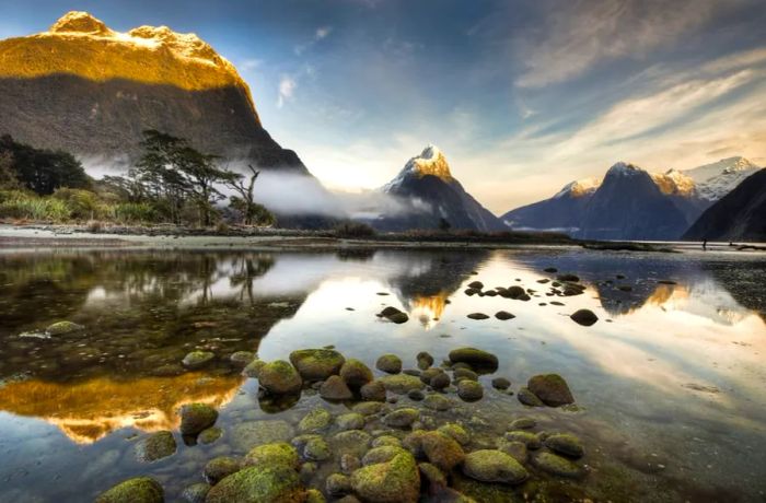 As dawn breaks over Mitre Peak in Milford Sound, the most iconic of the 15 fjords within Fiordland National Park, the landscape comes alive in a breathtaking display.