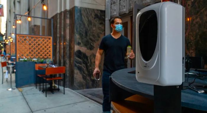 A hand sanitizer station is set up in the outdoor dining area of Crown Shy restaurant in New York.