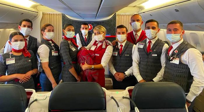 Turkish Airlines crew members pose with the baby they helped deliver.