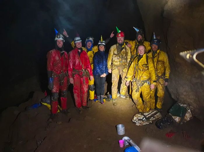 The cavers celebrate reaching the depths of Delta Variant, marking a significant achievement in their adventure.