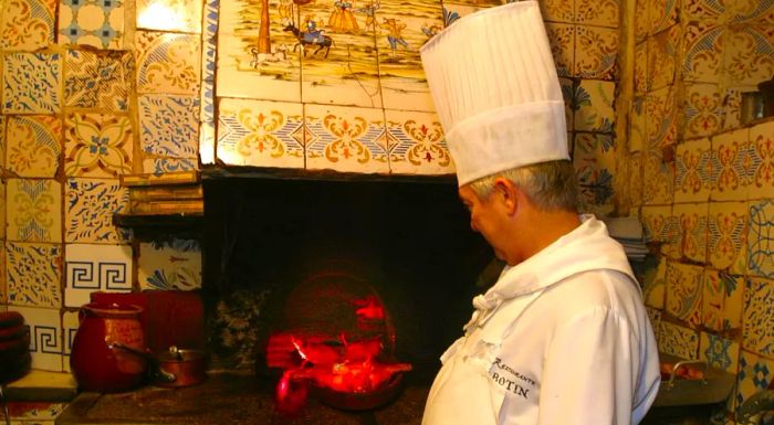 A Restaurante Botín staff member takes a roasted pig out of the oven.