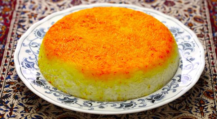 The word tahdig translates to 'bottom of the pot,' a nod to the dish's signature crispy, golden crust of rice that forms during cooking.