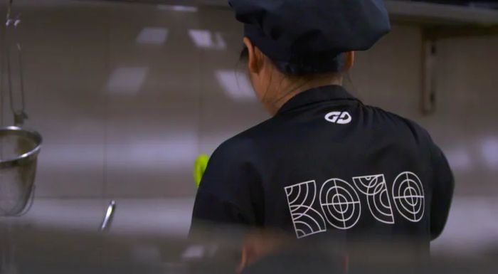 A KOTO trainee wears a branded black T-shirt while working at one of the restaurants.