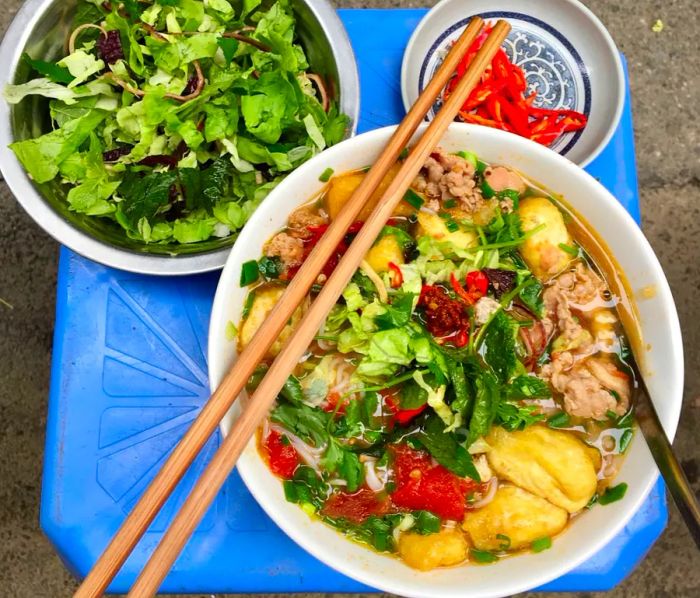 The first thing you'll notice about Bún Riêu – a vermicelli soup with meat or seafood – is its vibrant red color.