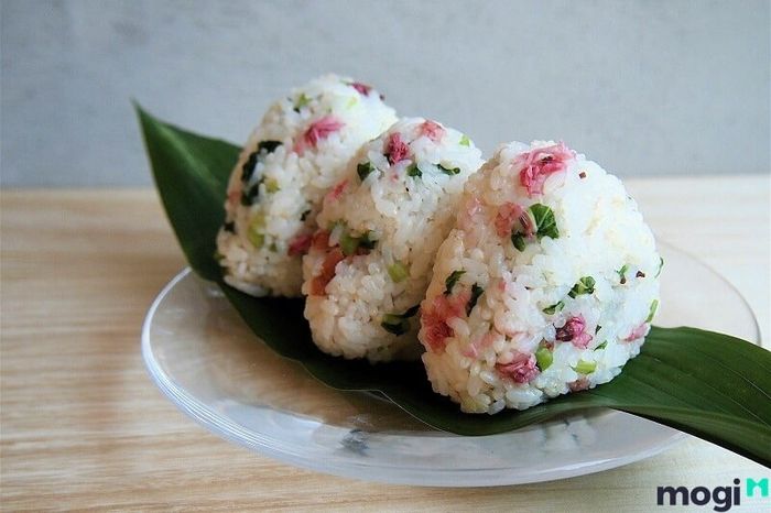 Cơm nắm hoa anh đào – món ăn dễ dàng mang đi mọi nơi, kết hợp giữa hương vị thơm ngon của cơm với gia vị đặc biệt từ hoa anh đào.