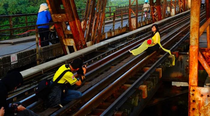 This 2014 file photo shows a girl in traditional dress posing for a photo on the historic Long Bien Bridge. Local reports indicate that the bridge is growing in popularity among both locals and tourists alike.