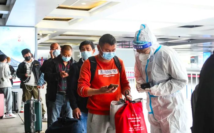 Covid workers inspect the travel information of passengers at a high-speed train station in Huai'an, China, on May 11.