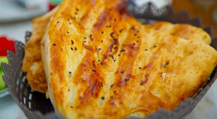 Tandir bread is glazed with egg or yogurt before being baked in a traditional clay oven.