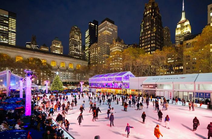 Skaters glide across the ice at night in the Bank of America Winter Village at Bryant Park.