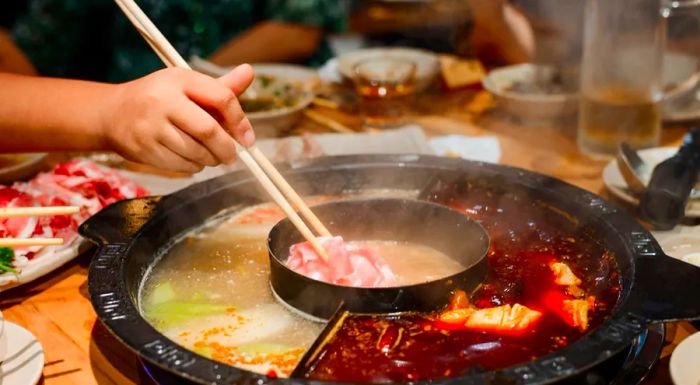 Hot pot features a variety of meats and vegetables, all simmered in a spicy, bubbling broth.