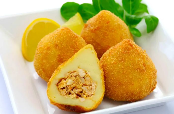 Coxinha are deep-fried dough balls stuffed with shredded chicken, a popular Brazilian snack.