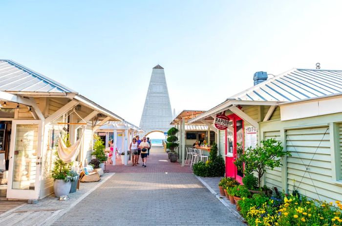 People stroll along a brick-lined path, flanked by shops, during the day.