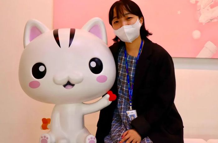 Choi Seo-young, a Goyang city official, stands proudly with the cat she helped bring to life.