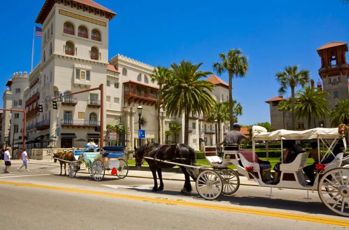 A horse-drawn carriage moves down a cobblestone street, passing by historic buildings.