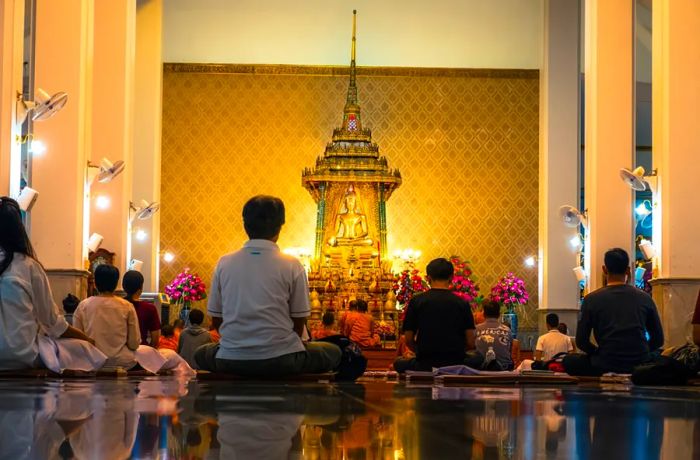 People meditate in a central Bangkok temple.