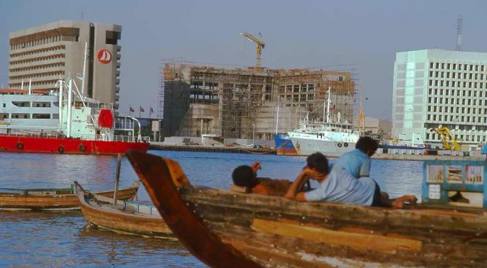 In this 1977 photograph of Dubai Creek, the men are gazing at the Municipality building under construction. 'You can imagine this might be their second or third visit to Dubai, and each time they’ve seen the Dubai Municipality building grow larger,' said Todd Reisz, the exhibition curator.