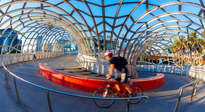 A cyclist pedals across the Webb Bridge in Melbourne's Docklands. Stretching over the Yarra River, this bridge is exclusively for cyclists and pedestrians.