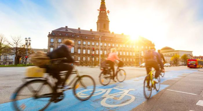 Cyclists in Copenhagen zip past the impressive Christiansborg Palace.