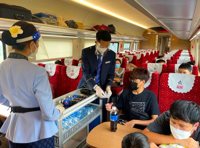 Railway staff wheel a drink trolley through the new semi-high-speed train.