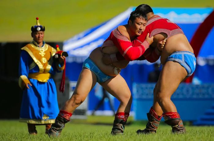 Mandatory Credit: Photo by Wu Hong/EPA/Shutterstock (8430301bm) - Mongolian people dressed in traditional attire compete in wrestling during the 'Nomadic Festival-Naadam' as part of the 11th Asia-Europe Meeting (ASEM) Summit of Heads of State and Government (ASEM11) in Ulaanbaatar, Mongolia, on July 15, 2016. Mongolia hosted the 11th ASEM Summit in its capital city from July 15 to 16, 2016. (Photo by Wu Hong/EPA/Shutterstock)