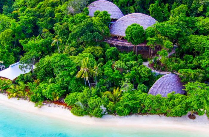 Nestled in the jungle, Bawah Island's bamboo bungalows emerge from the lush greenery.